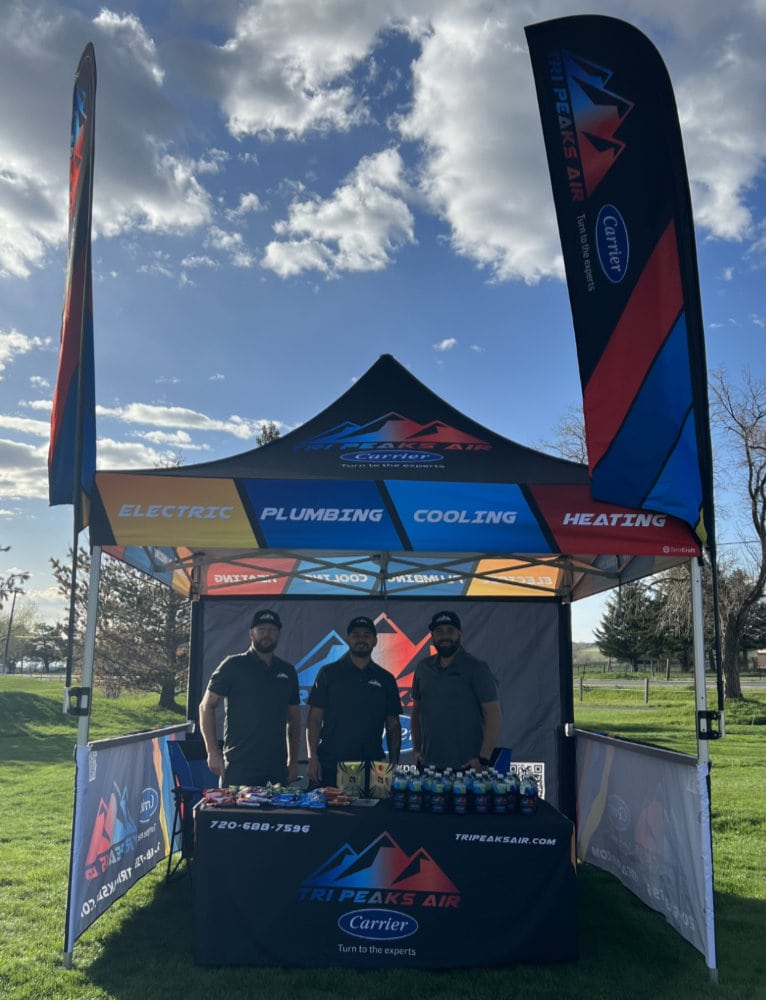 Tri Peaks Air team photo at an event with promotional materials. 